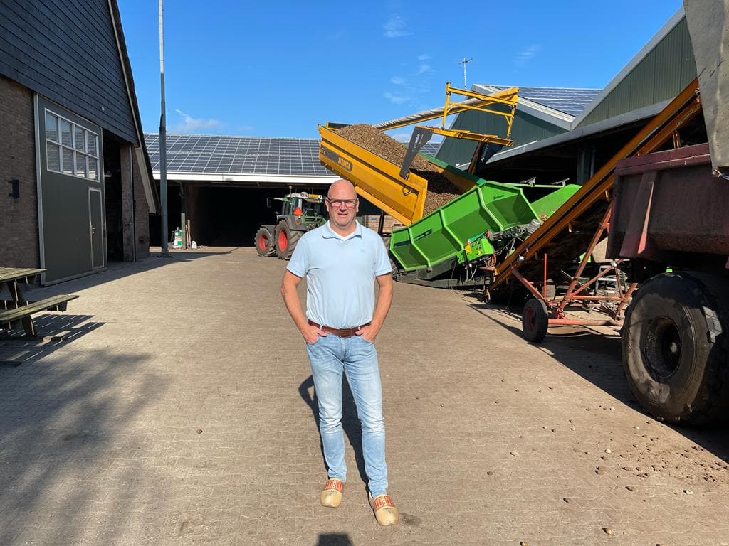 Pieter winter staat buiten zijn agricultureel bedrijf met handen in zijn zakken.