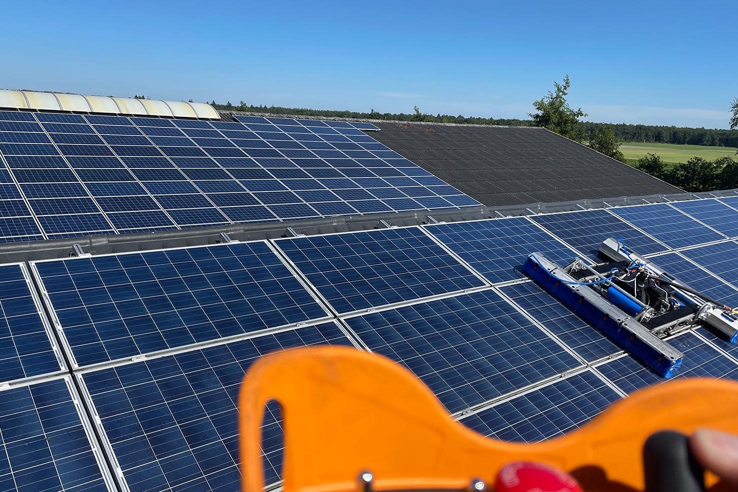 Zonnepanelen op de stal van Bart Bruin met de apparatuur om zonnepanelen te reinigen van Schoonmans op het dak