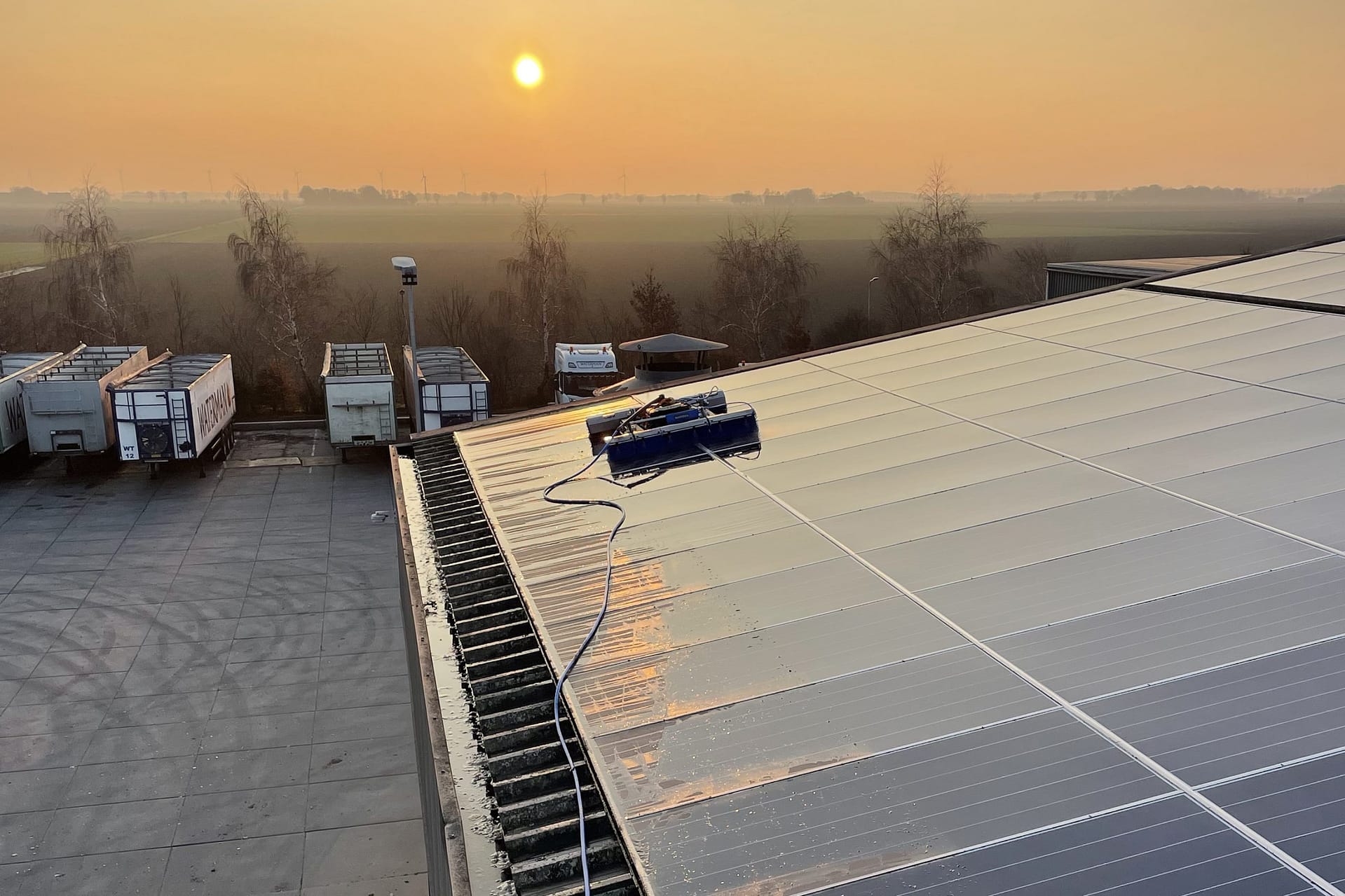 Zonnepanelen op dak van Waterman Onions bij avondzon met reflectie